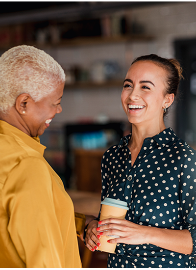 Een cursist en een mindfulness coach staan lachend tegenover elkaar